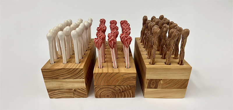 sculpture resembling matches mounted on wood boxes