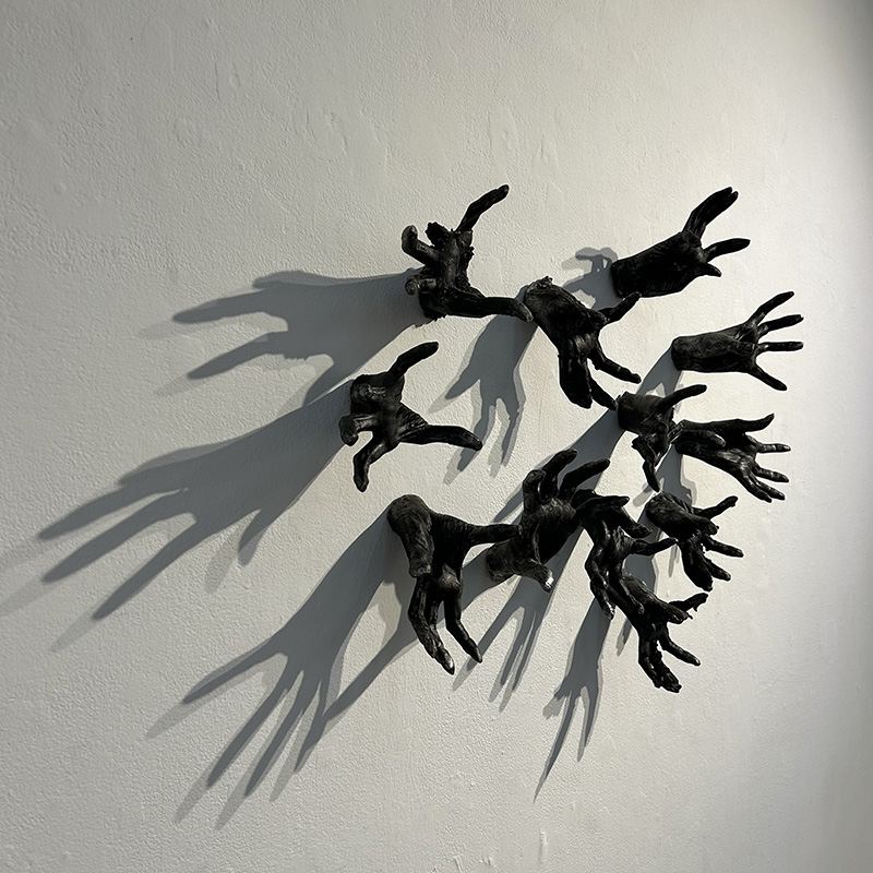 cast hands mounted on wall with shadow effects