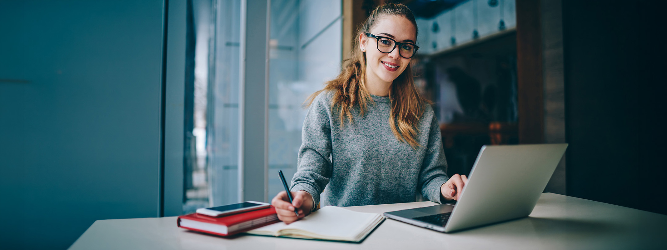 smiling female student at table with laptop
