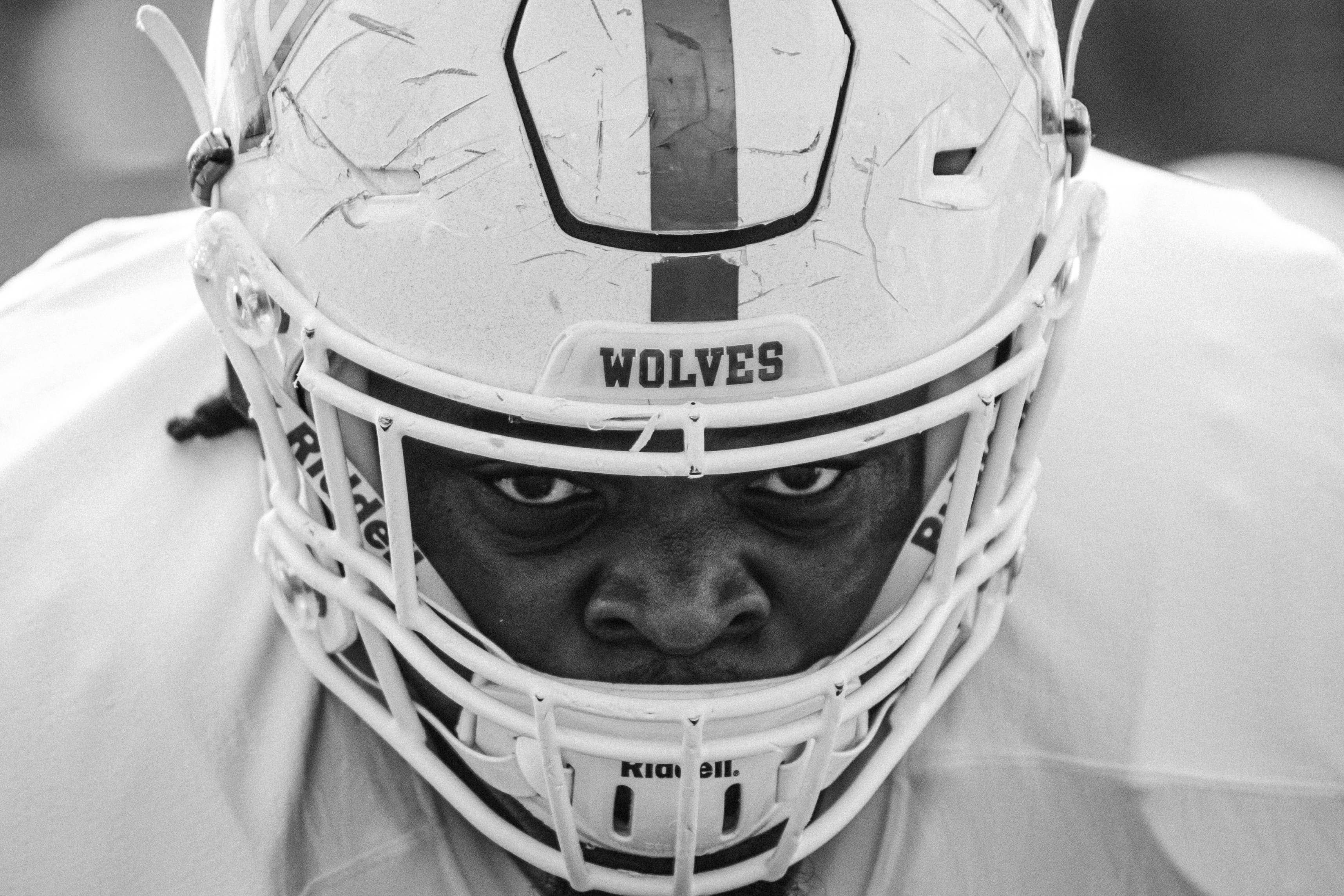 Football athlete closeup showing him wearing his football helmet with Wolves written across the front.