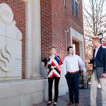 RCOB students dressed professionally walk past a monument to the old flame logo.