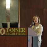 A representative from Tanner Health stands at a podium delivering a speech.