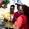 Lady with nice wavy braided hair wearing a red shirt standing looking off into the distance.