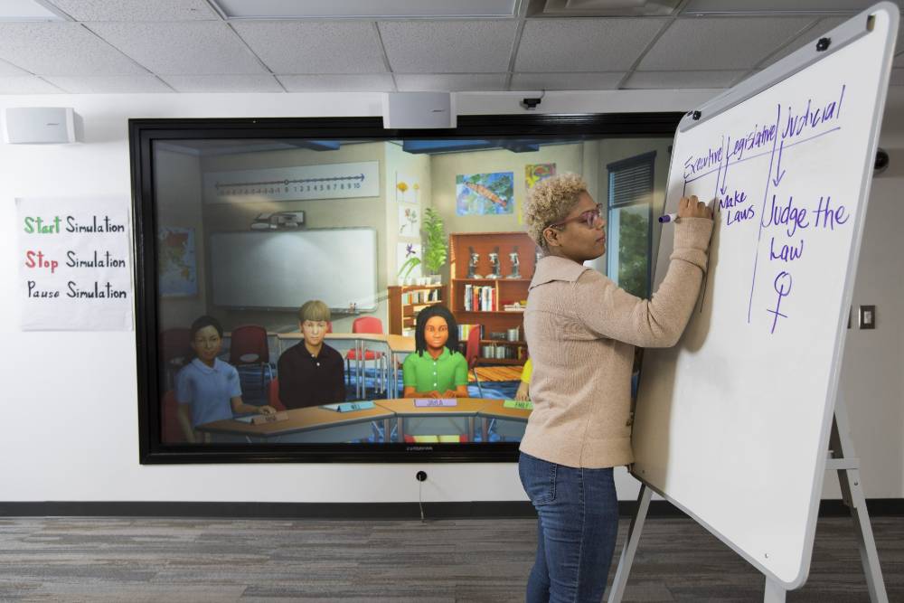 An educator teaching a group of simulated students in the UWGLive Simulations Lab