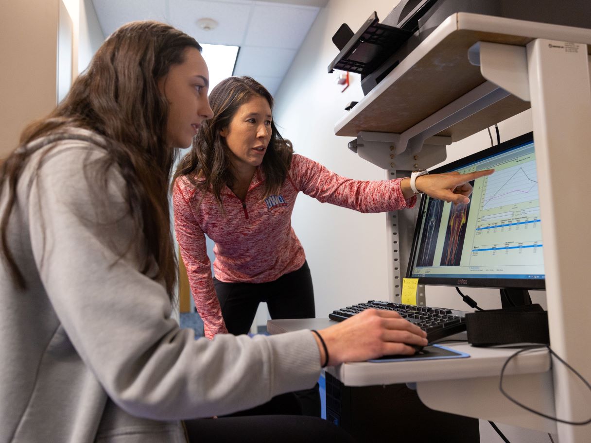 Professor and student discussing data on a computer