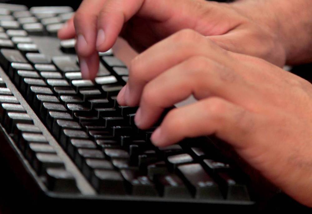 Hands typing on a keyboard.