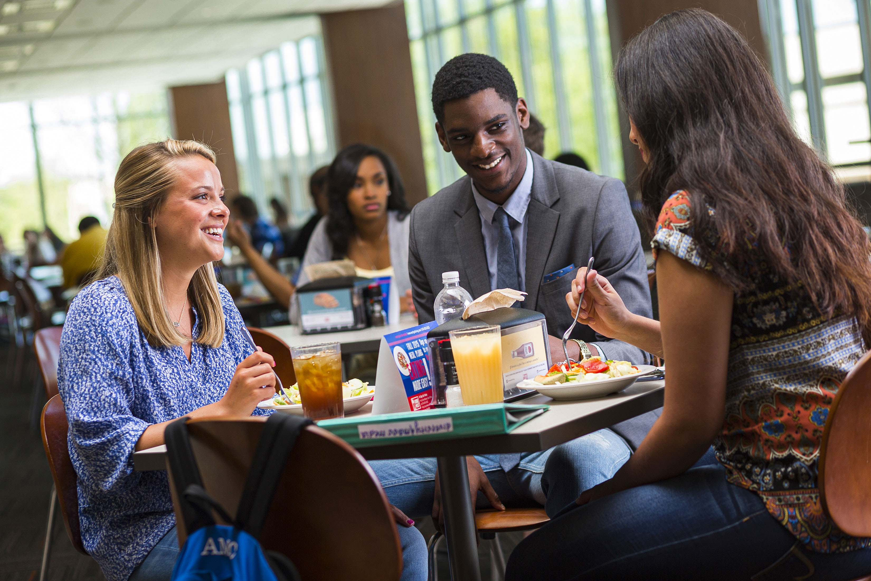 People sitting at table in dining hall. 