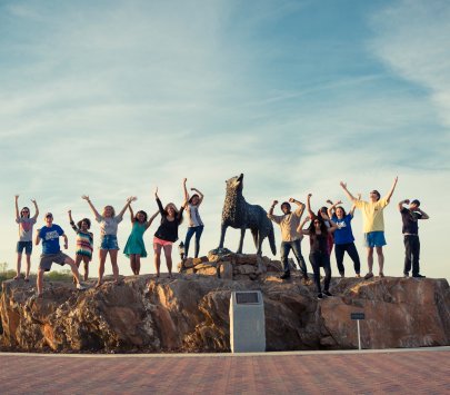 students cheer by wolfie statue