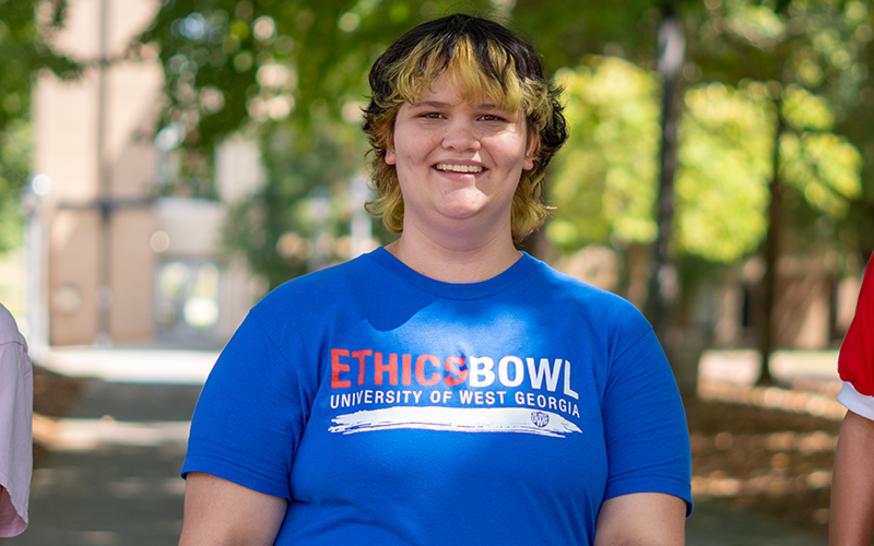 UWG student in blue shirt smiles at camera