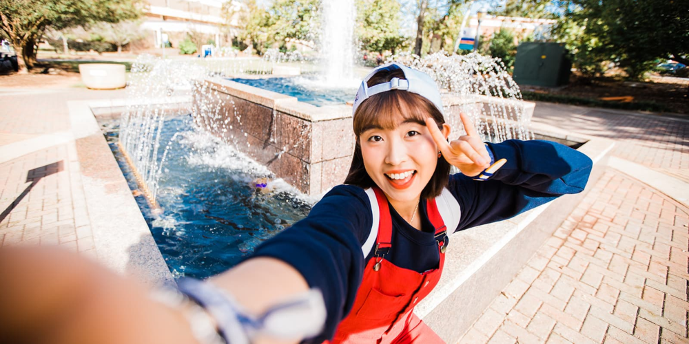 female student posing by the uwg fountain 