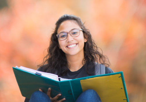female student smiling and reading