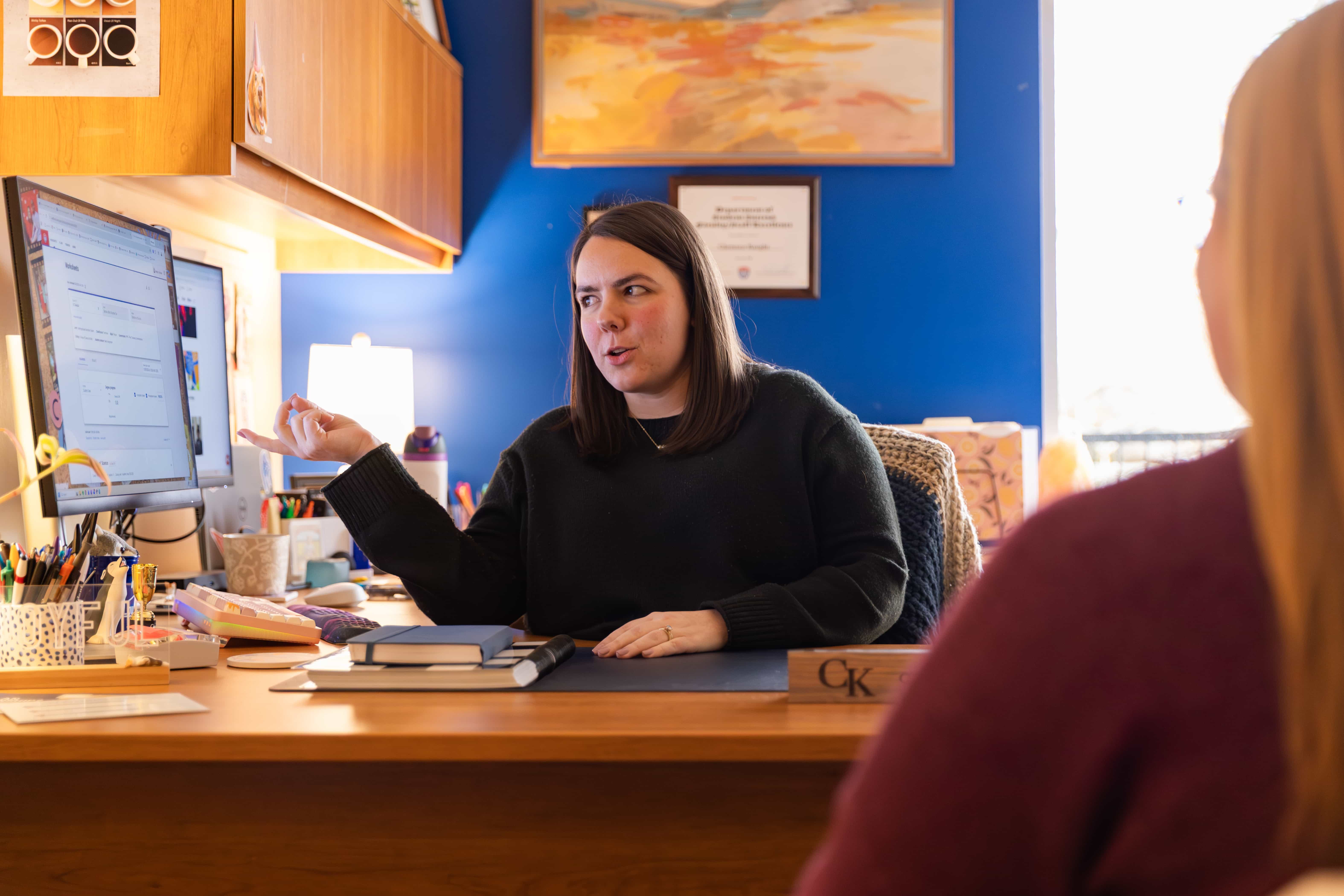 Advising and student sitting at a desk reviewing upcoming course options.