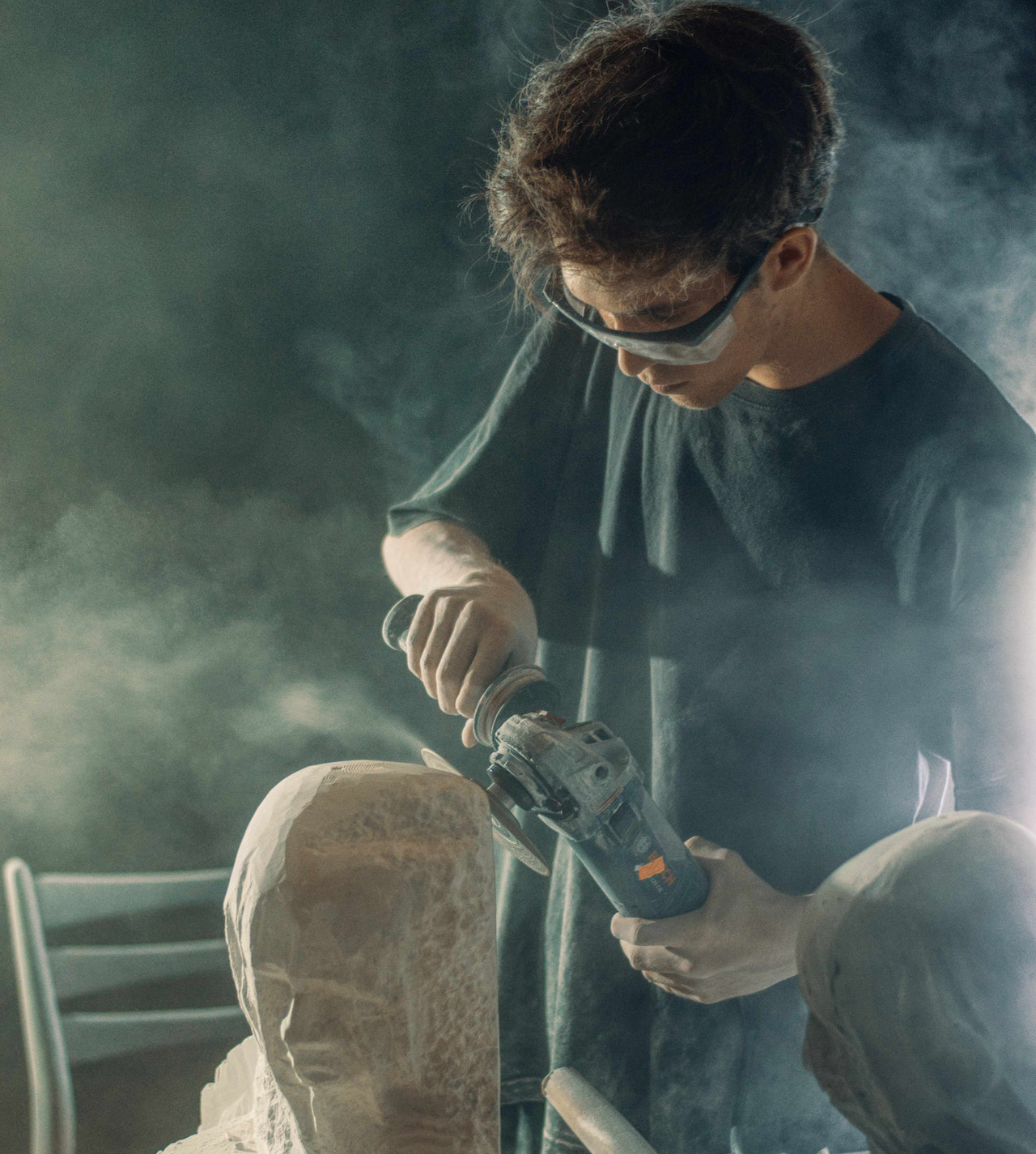 Guy sanding a clay statue