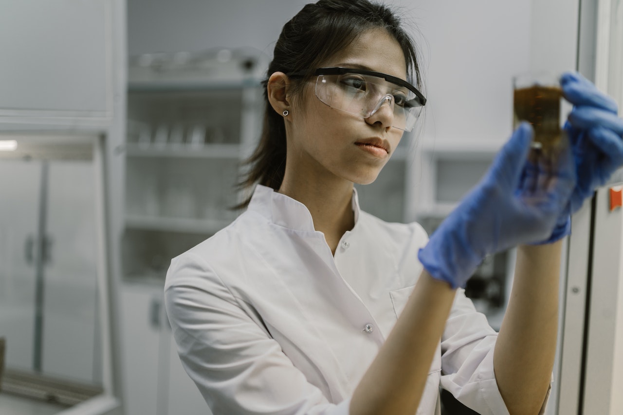 A woman holding a beaker with liquid in it