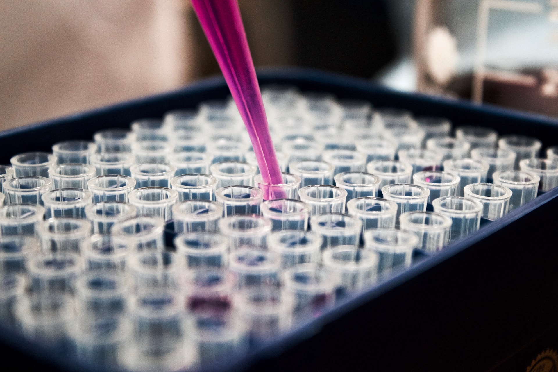 Someone using a drop to put liquid in a test tube