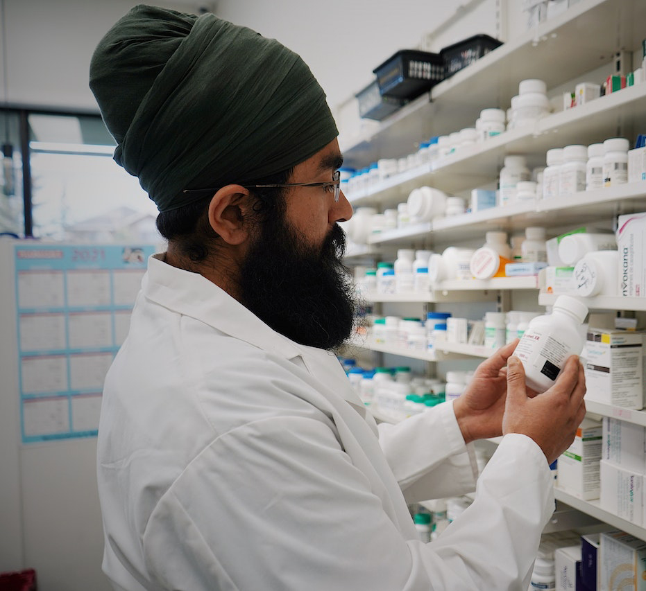 Pharmacist in front of Shelves with Medicines