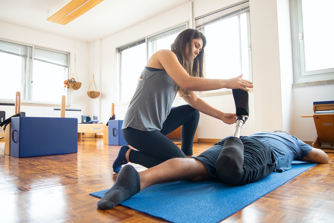 Physical therapist helping a client with a prosthetic leg