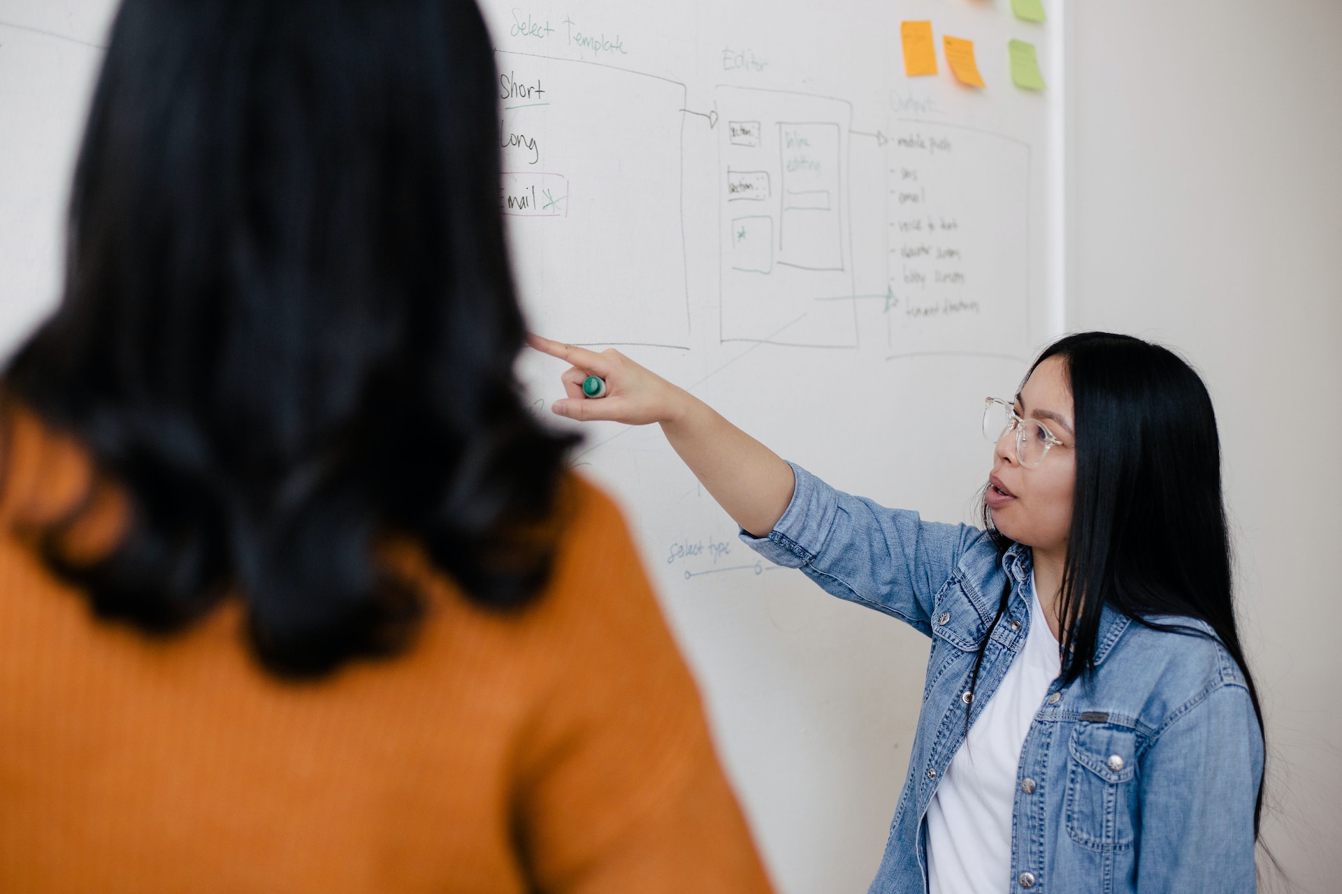 Woman pointing at a dry erase board