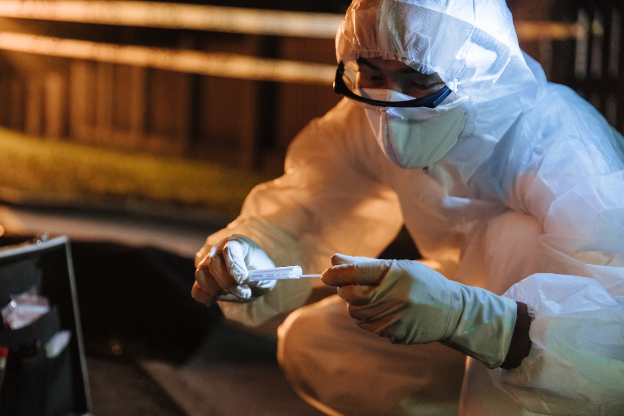 Man in protective gear and White Gloves Holding White Plastic Pack