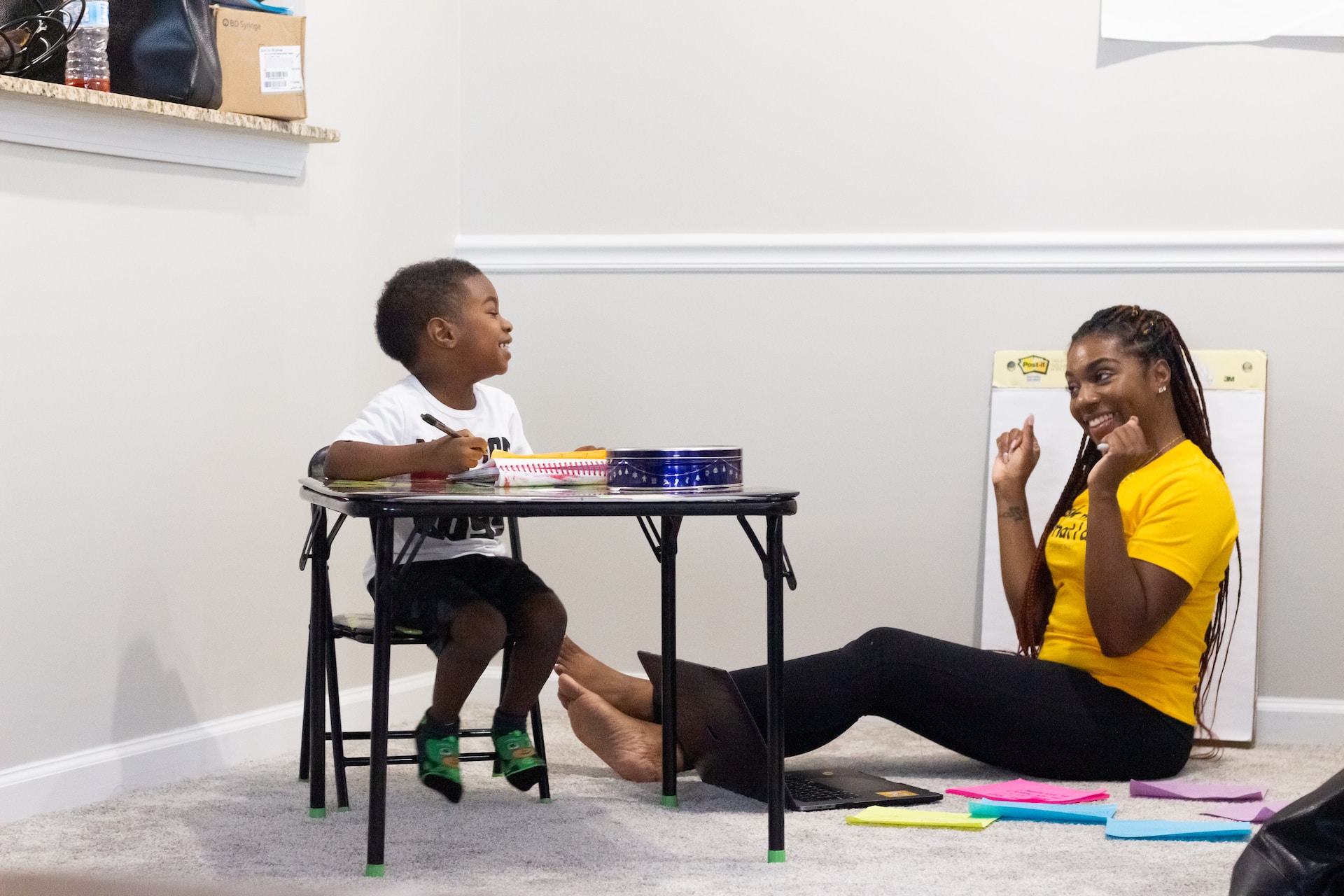 Woman teaching a child. The child is laughing