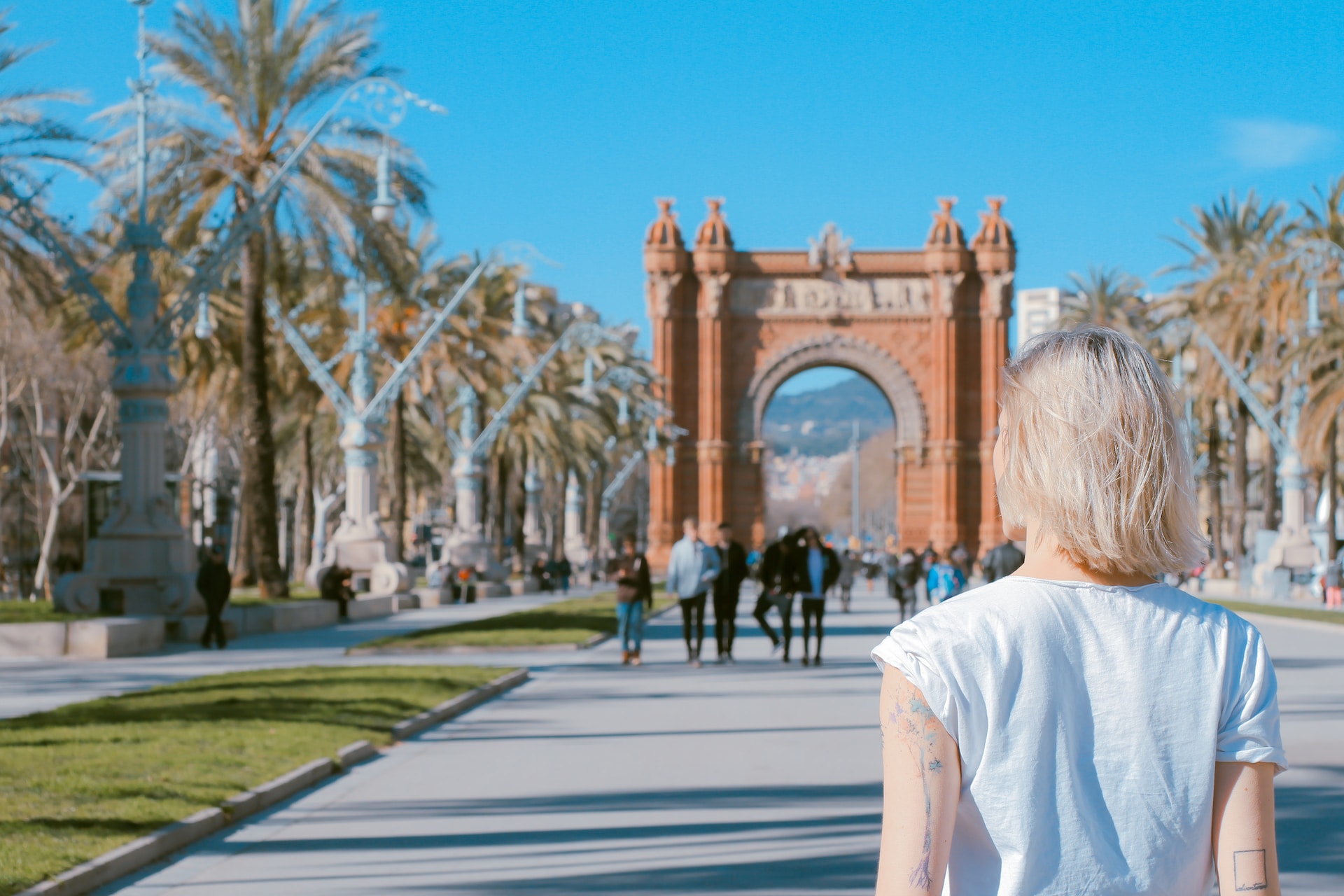 woman standing on road near the  Arco de Triunfo de Barcelona in Spain