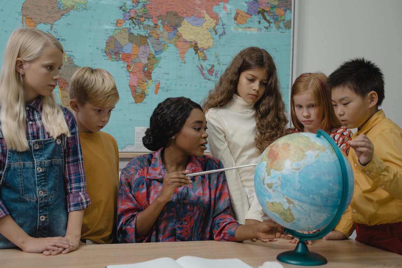 A teacher teaching geography using a globe