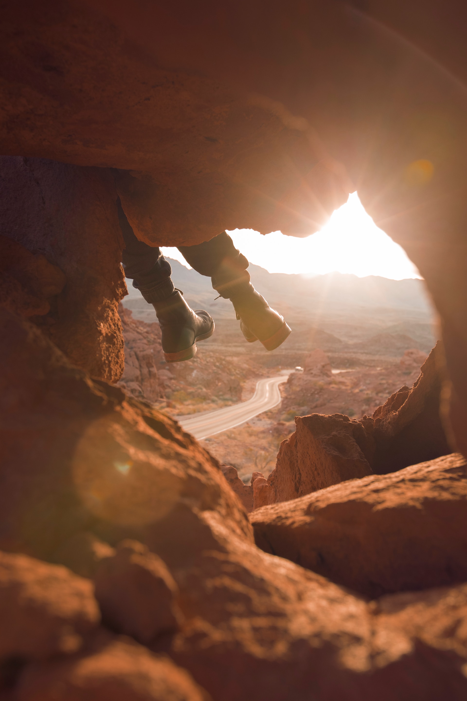 Person's boots hanging over rock wall