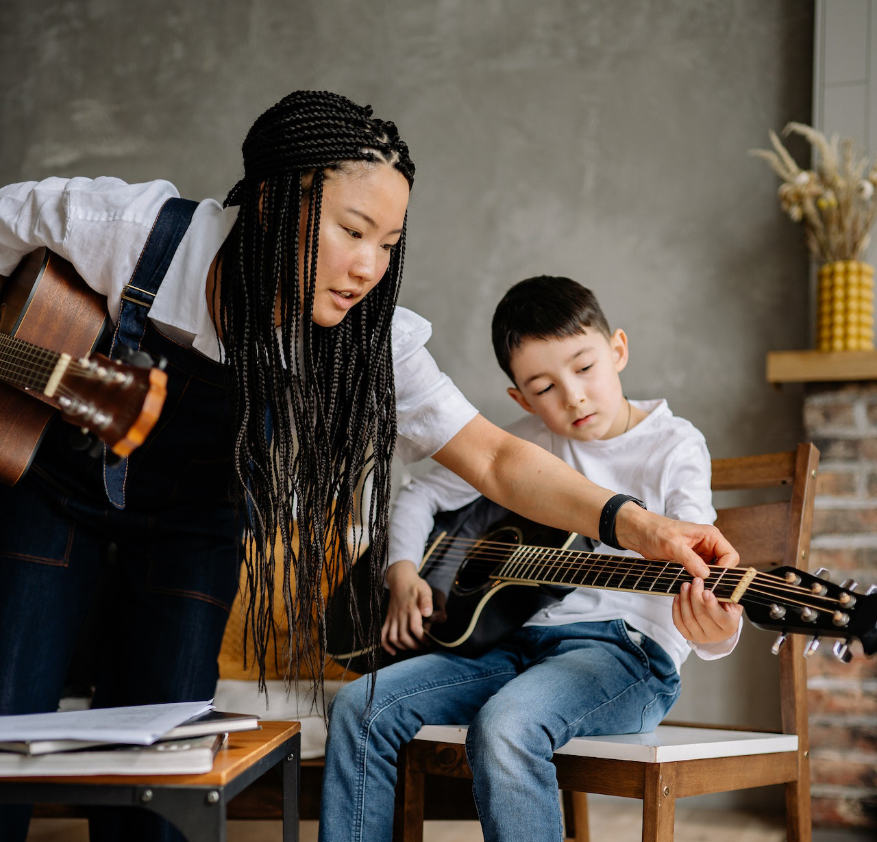 Female music teacher teaching a child the guitar