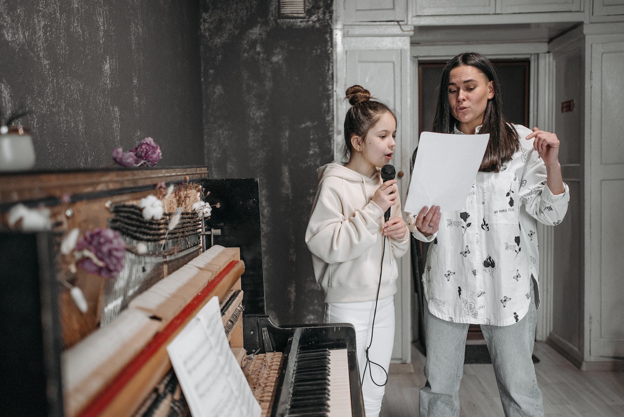 A female music teacher teaching a student to sing