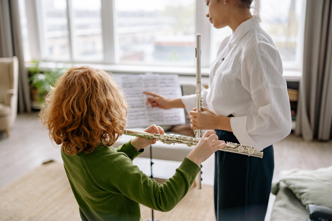 Woman teaching a student the flute