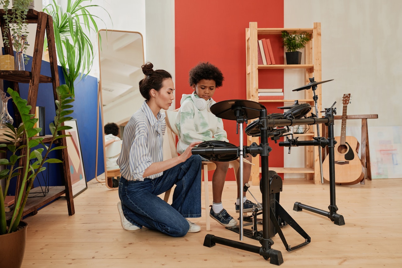 A female music teacher teaching a student the drums