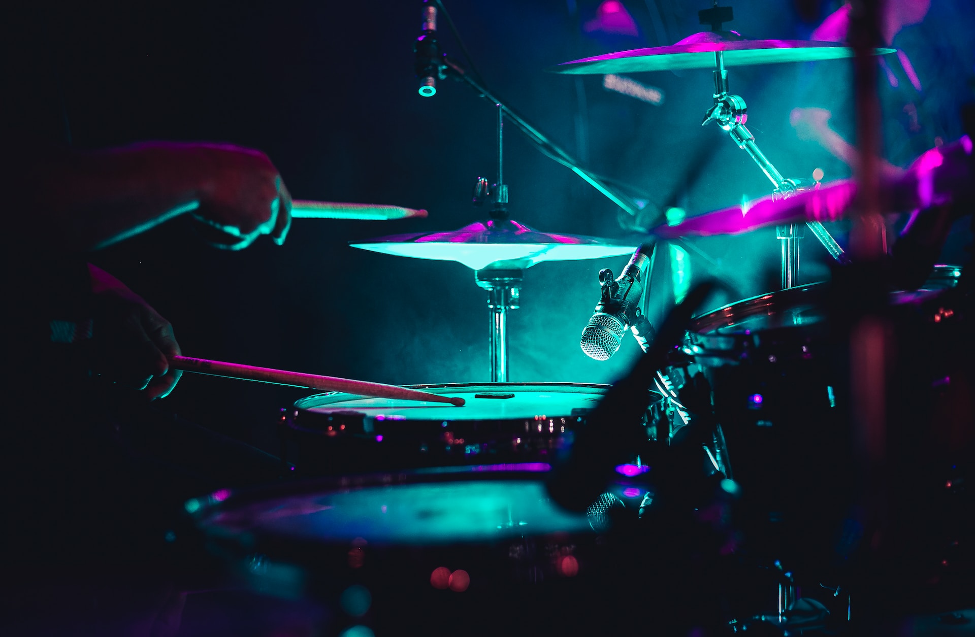 A set of drums in green/blue lighting