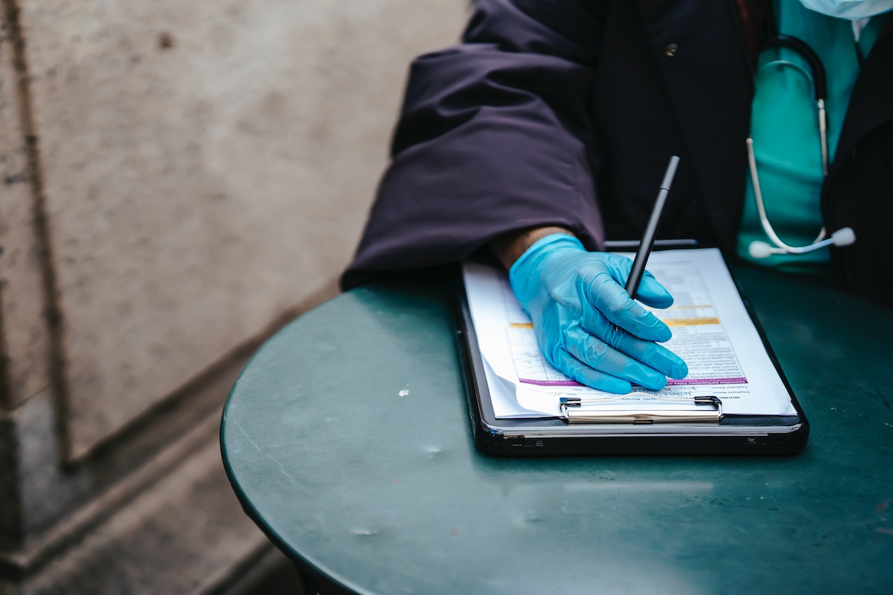 Cropped image of a black doctor with documents at table