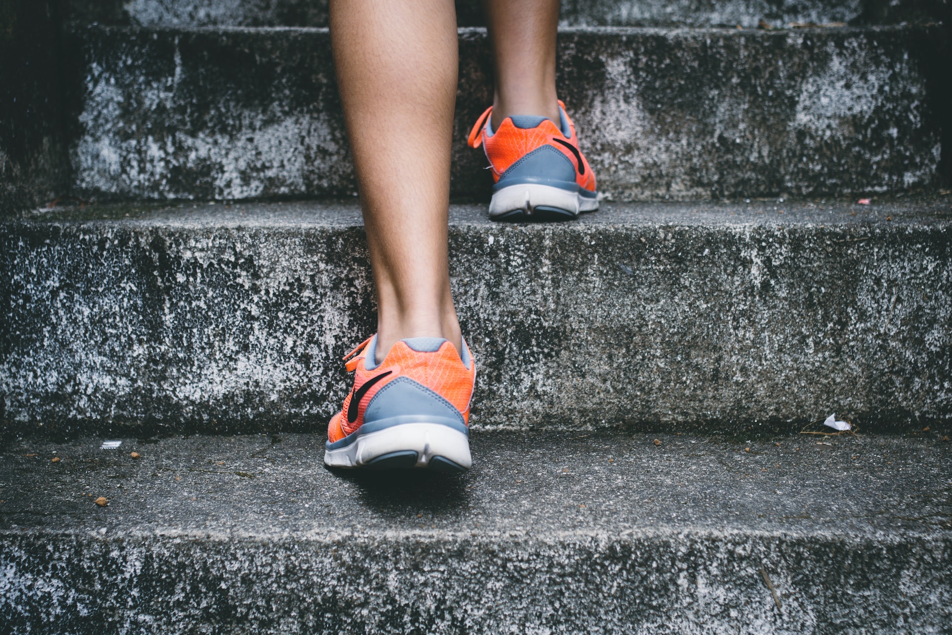 Person walking up stairs with the shoes as the focal point