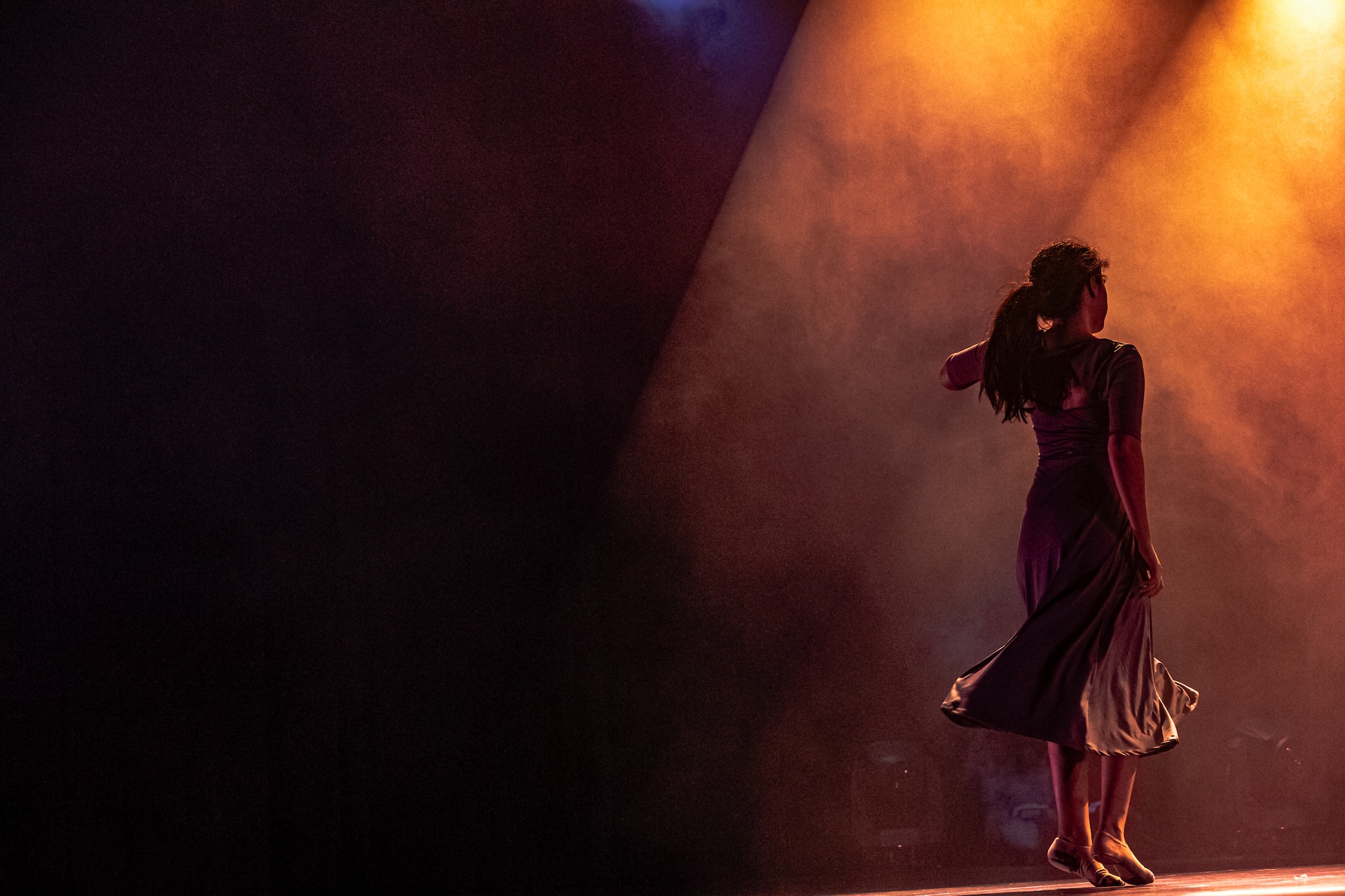 Female dancers on stage for a story based performance amid beautiful light effects and graceful movement.