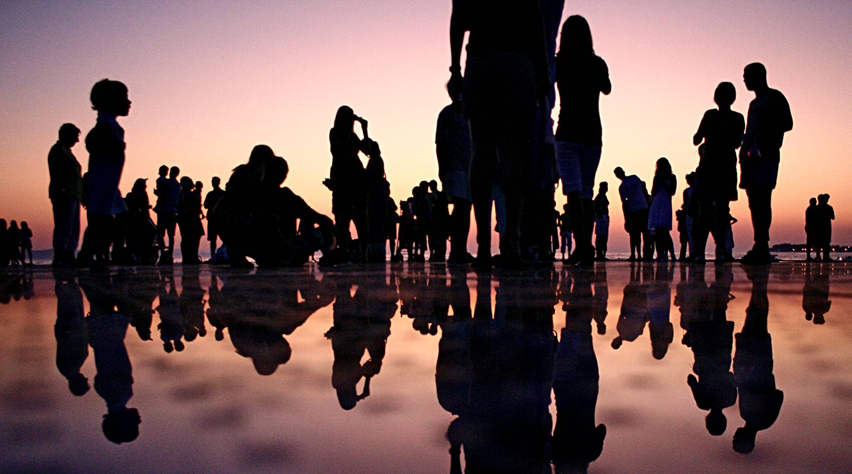 people and their shadows on beach shoreline