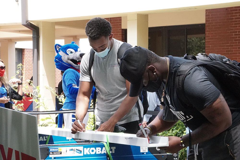 Business students sign one of the structural beams for Roy Richards Sr. Hall at the annual Welcome Back Ice Cream Social.