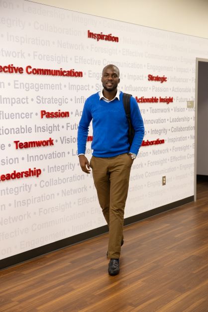 student walking in Richards College of Business.