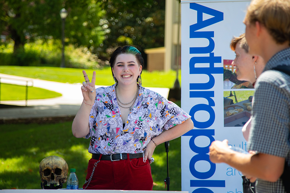 student smiling at an anthropology tabling