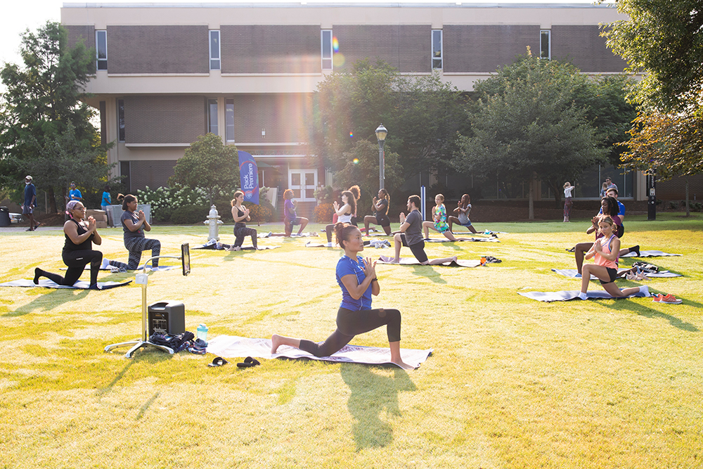 students doing yoga outside of library