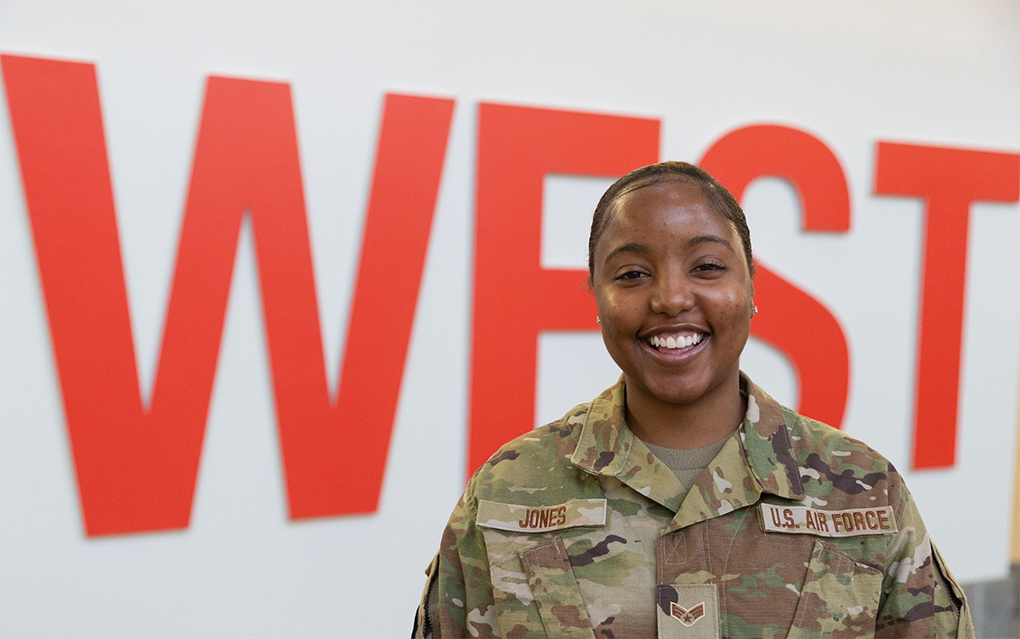 Student in Air Force uniform in front of "WEST" sign in Campus Center