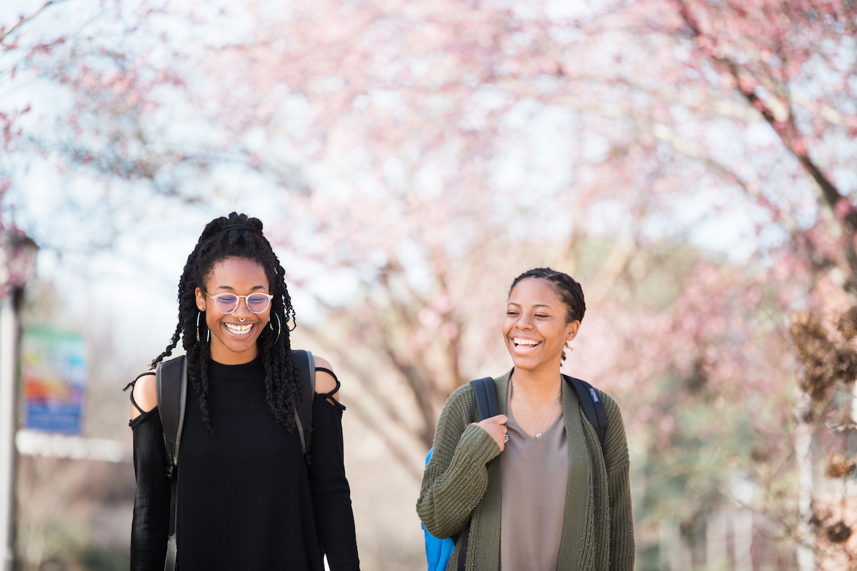 Students smiling outside walking to class.