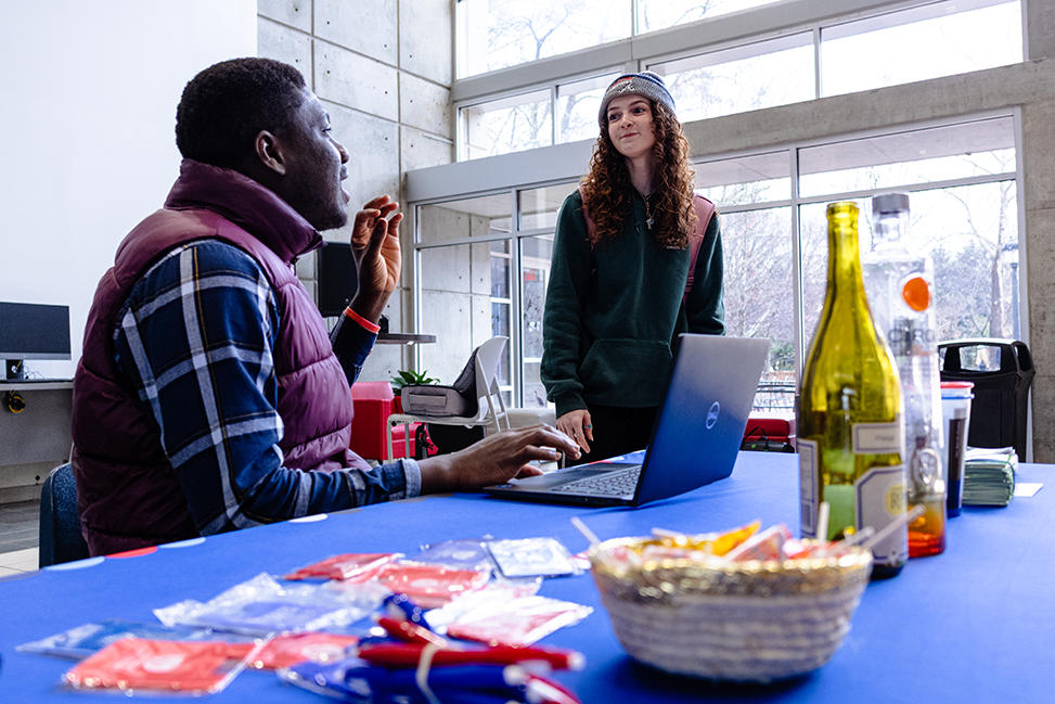 Peer educator talking to a student at a tabling event