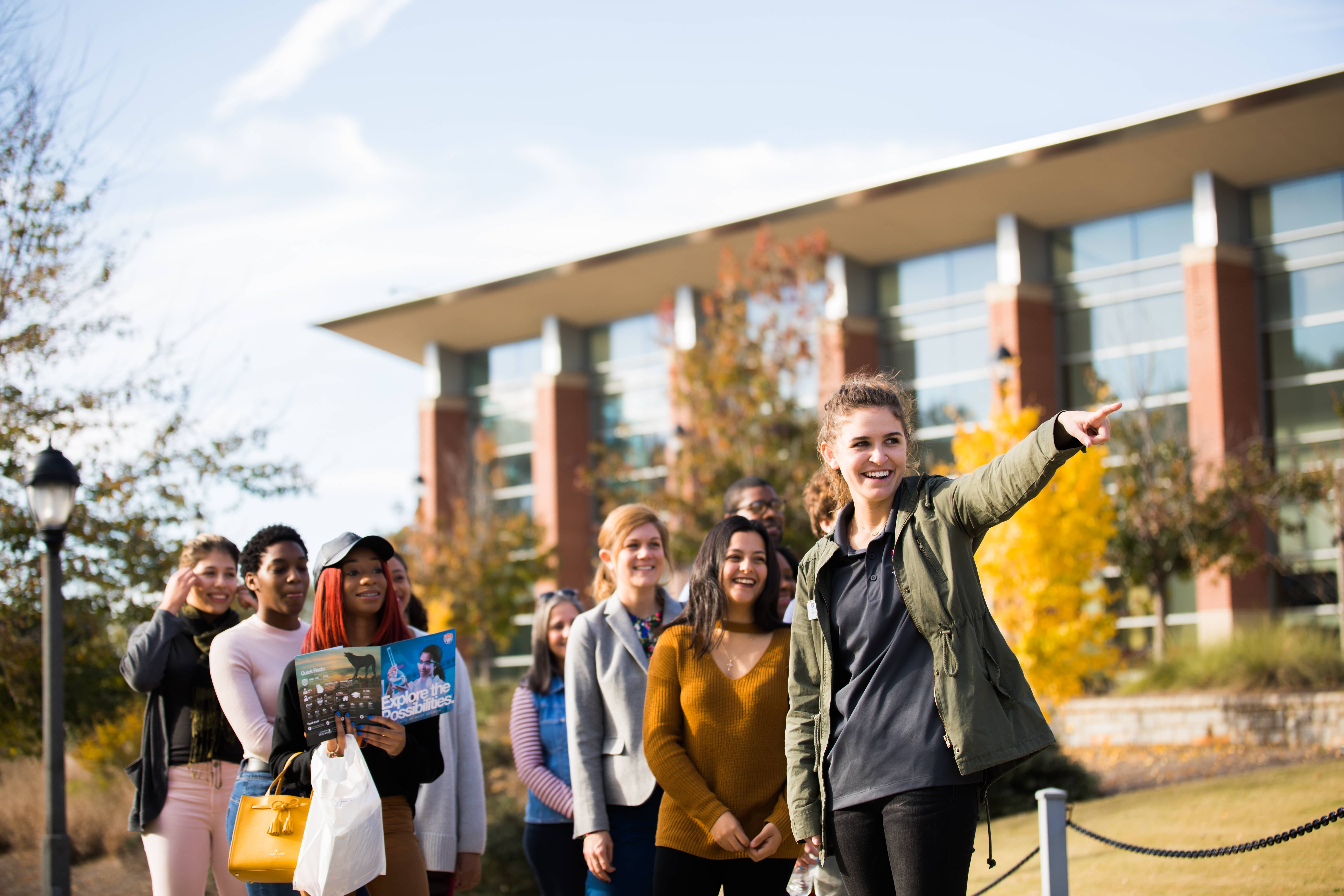 Students walking and smiling during a tour through campus.