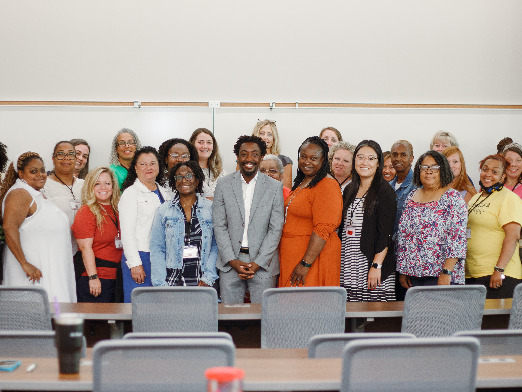 Group of teachers standing together for a group photo in front of a classroom.