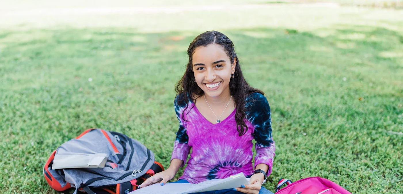 girl smiling seated on grass
