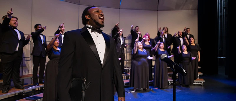 student singing in front of a choir