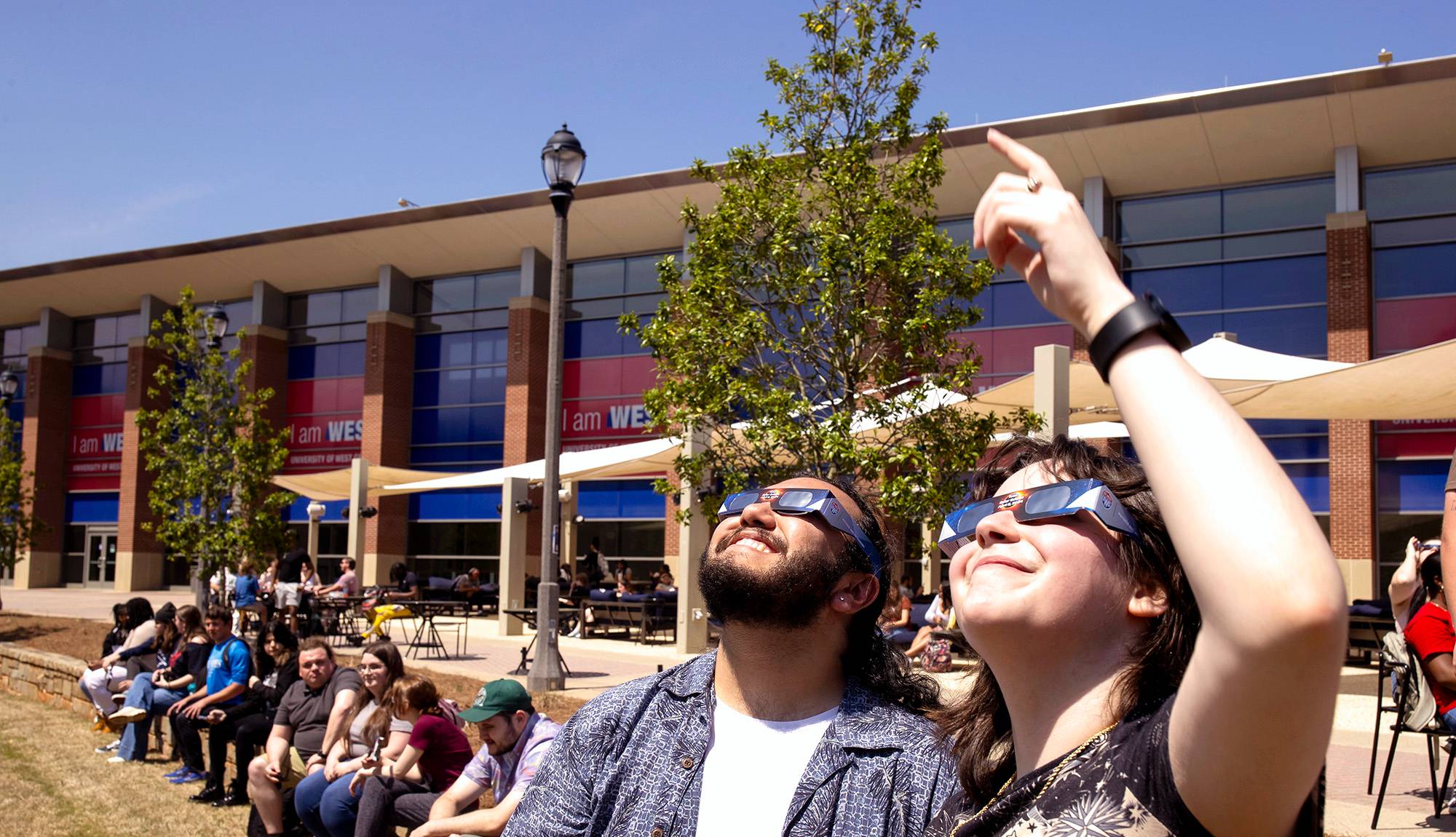Students watching eclipse with glasses.