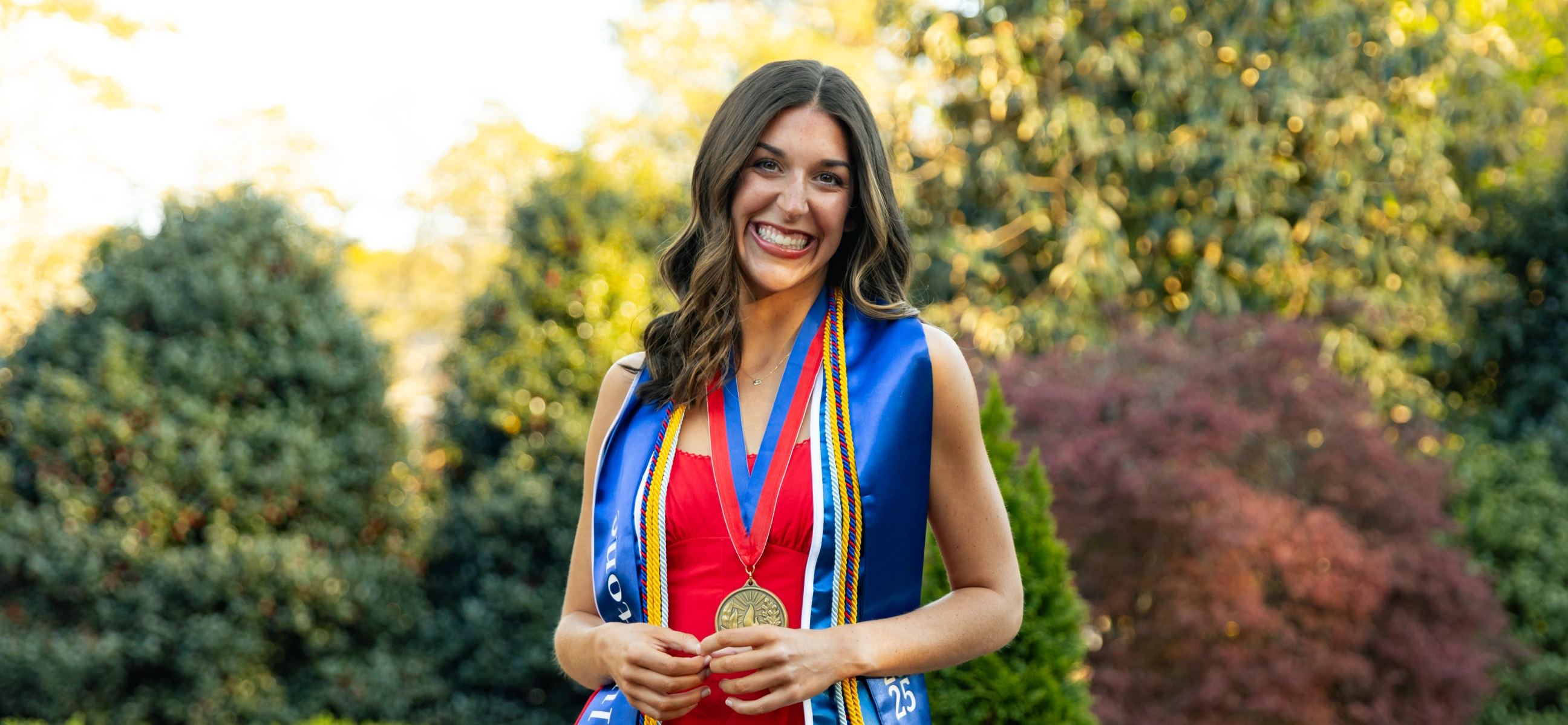 Lauren posing for graduation photos in the Alumni Garden.