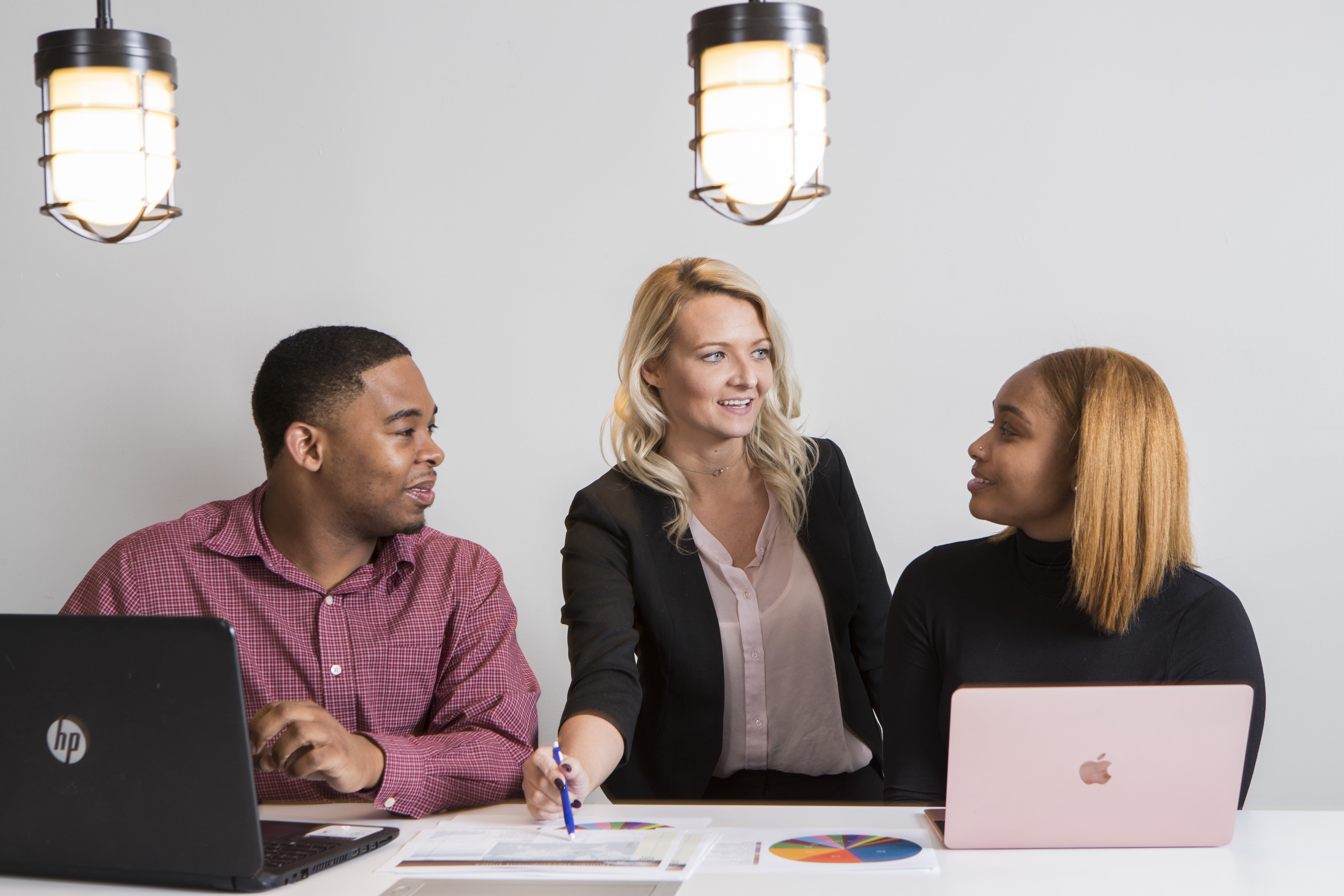 Three colleagues communicating at a table.